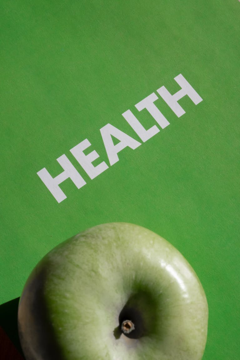 A green apple with 'Health' text on a vibrant green background symbolizing wellness.