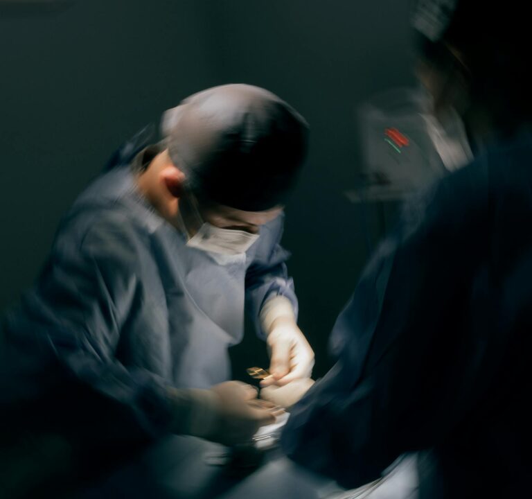 A team of surgeons focused on a critical surgery under operating room lights.