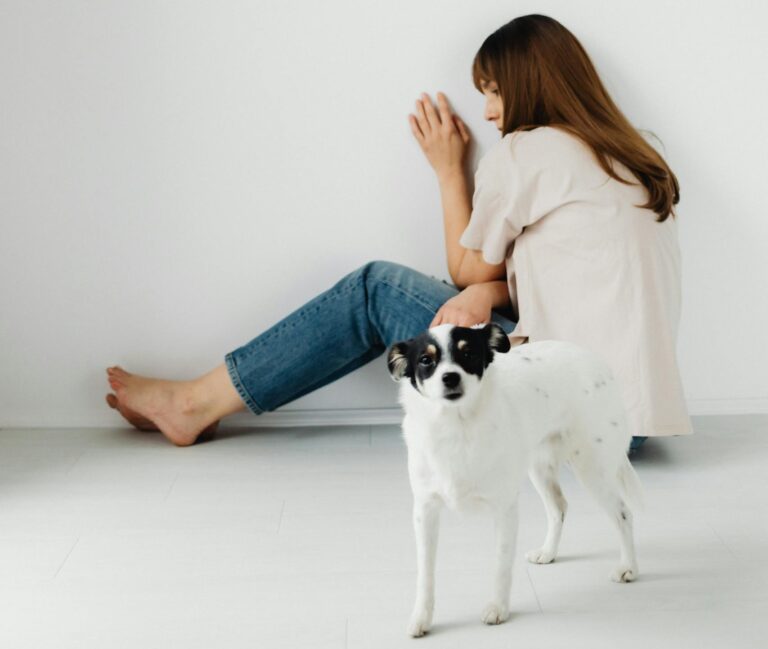 A woman seated with her dog in a minimalist room, conveying serenity and companionship.
