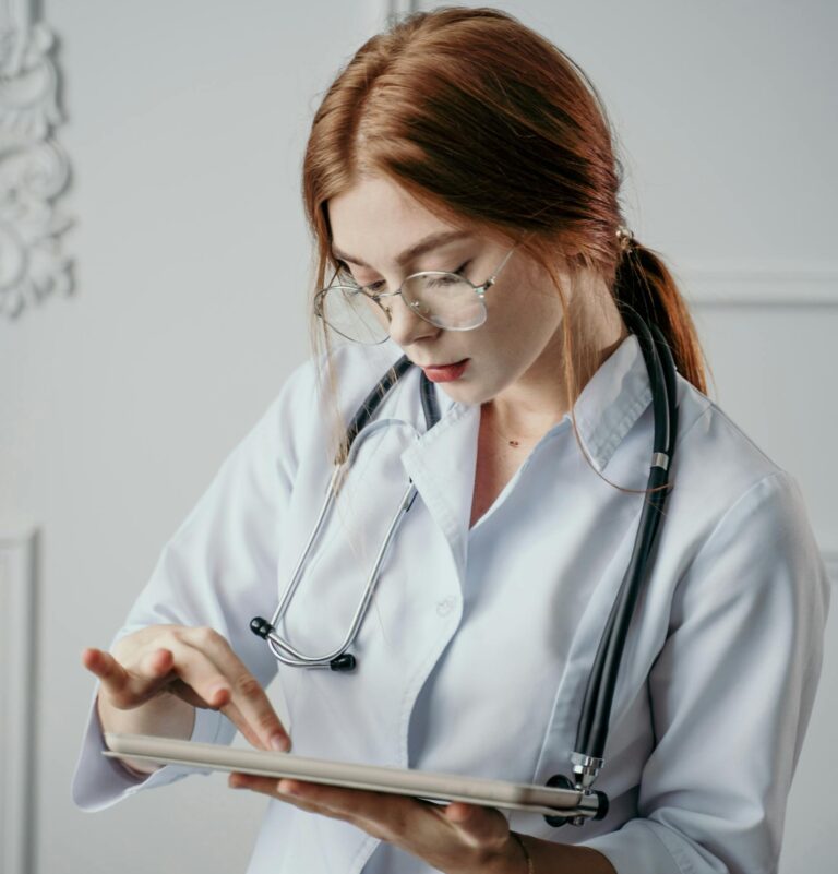 Female doctor using a tablet for medical diagnosis in a modern office setting.