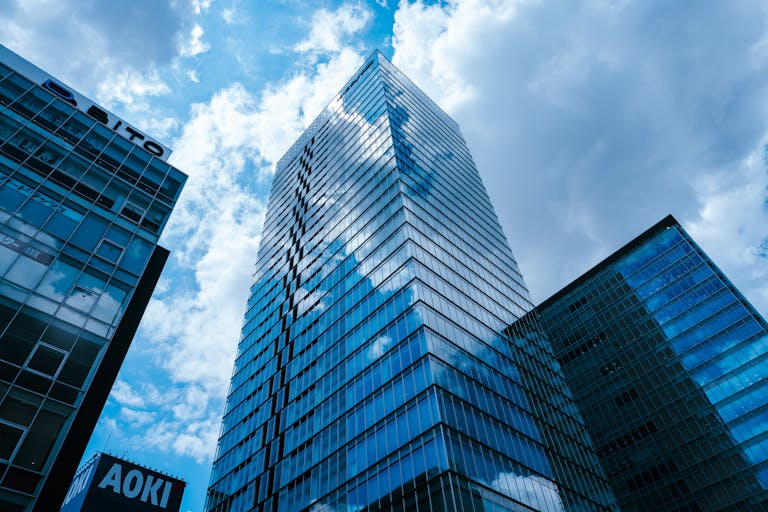 Stunning view of modern skyscrapers in Tokyo's Taito area, reflecting clouds.